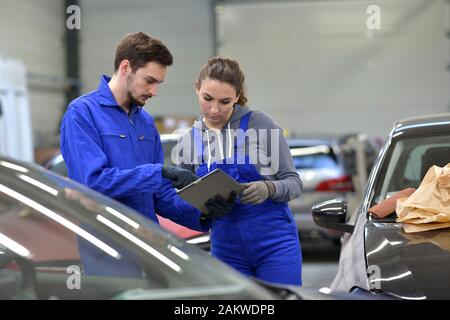 Apprentice in car industry using digital tablet Stock Photo