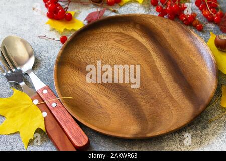 Autumn table setting. Thanksgiving or autumn harvest table setting with silverware and frame of leaves. Free space for your text. Stock Photo