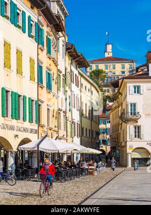 Udine - February 2017, Northern Italy: Woman in the red jacket is cycling in the center of the city. Stock Photo