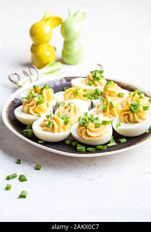 Deviled eggs in rustic ceramic plate, Easter party snack, close up Stock Photo