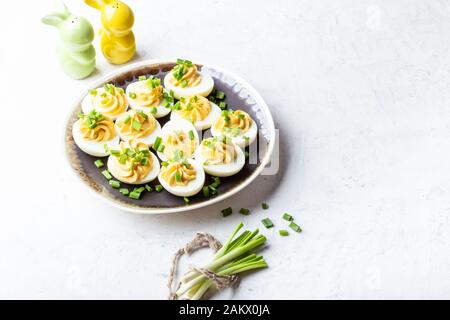 Deviled eggs in rustic ceramic plate, Easter party snack, close up Stock Photo
