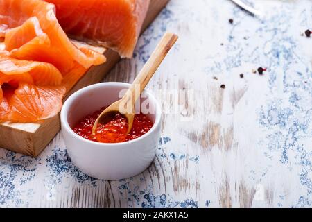 Festive brunch with cured salmon and pot of  salmon caviar on rustic table close up Stock Photo