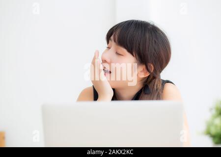 beautiful young freelance asian woman working bored and tired on laptop computer at the office, girl lazy sleepy and yawning on notebook, female secre Stock Photo