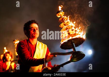 VARANASI, INDIA, JANUARY 18, 2019 : Portrait of a young Hindu priest waving fire candelar during the Ganga Aarti ceremony along the river bank Stock Photo