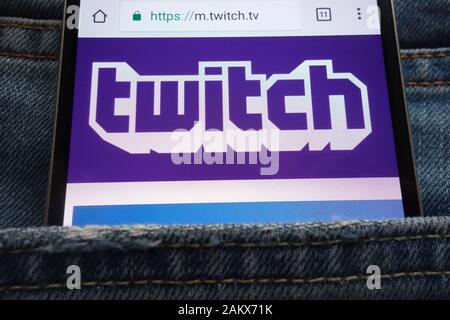 Twitch website displayed on smartphone hidden in jeans pocket Stock Photo