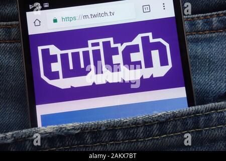 Twitch website displayed on smartphone hidden in jeans pocket Stock Photo