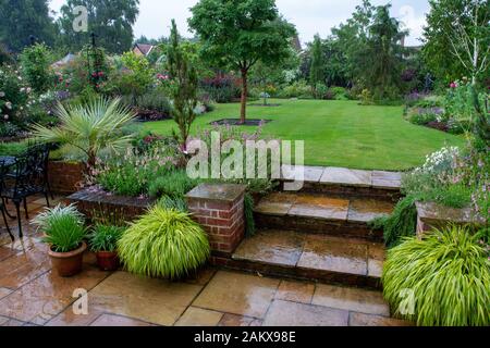 Three flagstone steps in a beautifully designed garden Stock Photo