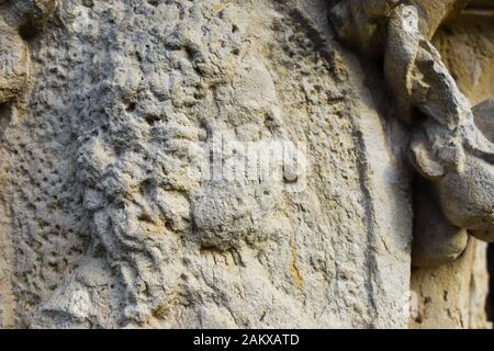 A close up view of a mans face in worn stone relief Stock Photo