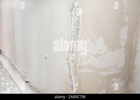 Damaged corners of plastered walls, visible aluminum corner. Stock Photo