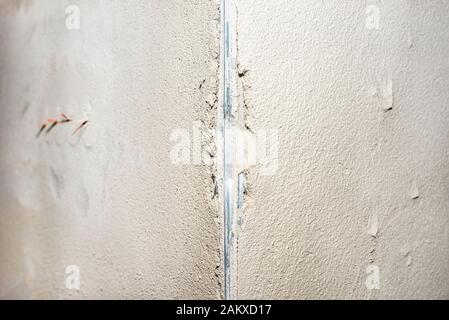 Damaged corners of plastered walls, visible aluminum corner. Stock Photo
