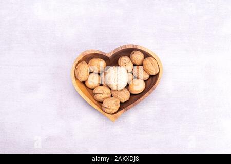 Walnuts love healthy brain foods. The shape of the human brain is surrounded by walnut kernels in the shape of a heart Stock Photo