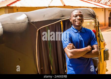 young african man driving a rickshaw taxi counting his money smiling Stock Photo