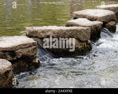 The famous Stepping Stones across the River Dove below the flanks of Thorpe Cloud in Dovedale, Derbyshire Stock Photo