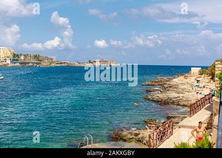 People bathing in Baths of Sliema, commonly known as Roman Baths or Fond Ghadir Stock Photo