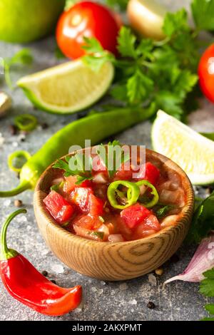 Traditional Latin American mexican salsa sauce with ingredients on a light stone table. Stock Photo