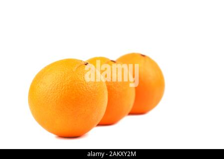 Soft focus. Three ripe oranges isolated on white background. Unpeeled ripe oranges. Copy space. Stock Photo