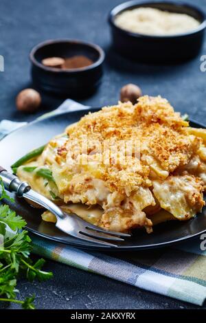 close-up of cheesy Potato and green bean casserole with crunchy breadcrumbs topping served on a plate, horizontal view from above Stock Photo