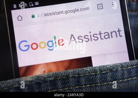 Google Assistant website displayed on smartphone hidden in jeans pocket Stock Photo