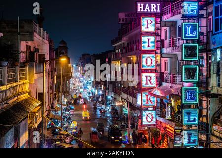 Night view of Main Bazaar street in Paharganj showing neon signs and traffic in Central Delhi, India. Stock Photo