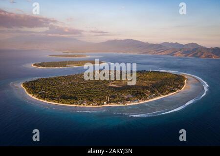 Aerial view of the Gili Islands off the coast of Lombok, Indonesia, at sunset. The Gilis are the most popular tourist destination in Lombok.