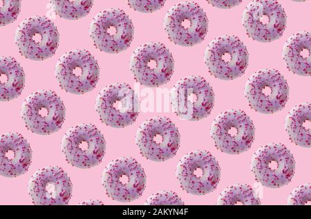 Many purple donuts on pink background. Texture concept. Stock Photo