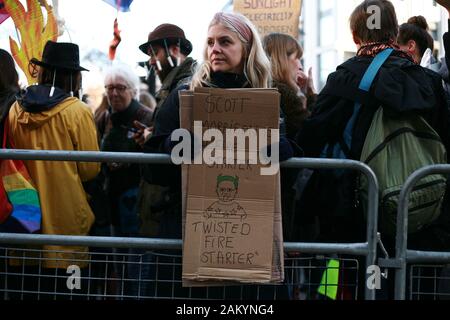 A woman holds a placard during a demonstration by members of the climate change activist movement Extinction Rebellion (XR) against Australian government's response to its ongoing bush fires outside the Australian High Commission in London.Wildfires have burned more than 12 million acres of Australian land since September last year, with the states of New South Wales and Victoria most severely affected and with the fire season still far from over. Australian Prime Minister Scott Morrison is facing intense criticism over his handling of the crisis, including his decision to go on holiday to Haw Stock Photo