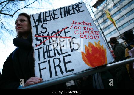 Protester holds a placard during a demonstration by members of the climate change activist movement Extinction Rebellion (XR) against Australian government's response to its ongoing bush fires outside the Australian High Commission in London.Wildfires have burned more than 12 million acres of Australian land since September last year, with the states of New South Wales and Victoria most severely affected and with the fire season still far from over. Australian Prime Minister Scott Morrison is facing intense criticism over his handling of the crisis, including his decision to go on holiday to H Stock Photo