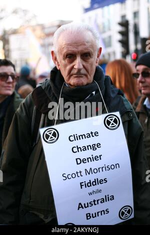 Peter Cole, a 76-year-old member of climate change activist movement Extinction Rebellion (XR) wears a placard during a demonstration against Australian government's response to its ongoing bush fires outside the Australian High Commission in London.Wildfires have burned more than 12 million acres of Australian land since September last year, with the states of New South Wales and Victoria most severely affected and with the fire season still far from over. Australian Prime Minister Scott Morrison is facing intense criticism over his handling of the crisis, including his decision to go on holi Stock Photo