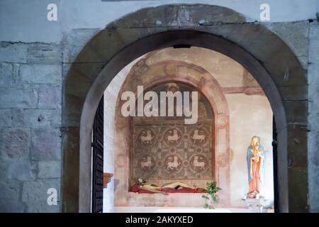 Blessing Christ between Saint Peter and Saint Paul, The pulpit is decorated with a fake orbiculus tapestry with lions in Chapel of the Assunta (Madonn Stock Photo