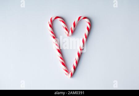 Candy canes arranged in a heart shape on a plain white background. Stock Photo