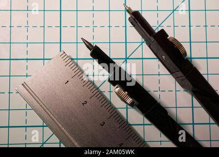 Drawing compass and a ruler on a geometric background. Macro image Stock Photo