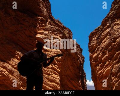 A man playing guitar at the Anphitheatre on the Salta Cafayate road,  Argentina Stock Photo