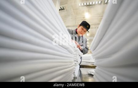 (200111) -- WUHAN, Jan. 11, 2020 (Xinhua) -- Wang Erling, a washing worker for train bedding, arranges the freshly ironed bedding at the washing center of Wuhan Passenger Transport Department in central China's Hubei Province, Jan. 6, 2020. China, the world's most populated country, on Jan. 10 ushered in its largest annual migration, 15 days ahead of the Spring Festival, or the Lunar New Year. This year, three billion trips will be made during the travel rush from Jan. 10 to Feb. 18 for family reunions and travel, according to official forecast. The 40-day travel rush is known as Chunyun in Stock Photo