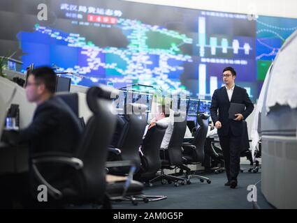 (200111) -- WUHAN, Jan. 11, 2020 (Xinhua) -- Li Song (R), a train dispatcher, is seen at the dispatching hall of China Railway Wuhan Group Co., Ltd. in central China's Hubei Province, Jan. 7, 2020. China, the world's most populated country, on Jan. 10 ushered in its largest annual migration, 15 days ahead of the Spring Festival, or the Lunar New Year. This year, three billion trips will be made during the travel rush from Jan. 10 to Feb. 18 for family reunions and travel, according to official forecast. The 40-day travel rush is known as Chunyun in Chinese. The Lunar New Year falls on Jan. Stock Photo