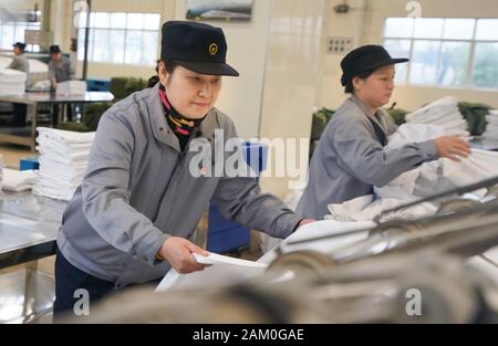 (200111) -- WUHAN, Jan. 11, 2020 (Xinhua) -- Wang Erling (L), a washing worker for train bedding, arranges the freshly ironed bedding at the washing center of Wuhan Passenger Transport Department in central China's Hubei Province, Jan. 6, 2020. China, the world's most populated country, on Jan. 10 ushered in its largest annual migration, 15 days ahead of the Spring Festival, or the Lunar New Year. This year, three billion trips will be made during the travel rush from Jan. 10 to Feb. 18 for family reunions and travel, according to official forecast. The 40-day travel rush is known as Chunyu Stock Photo