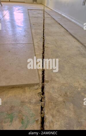 A giant crack in the foundation of a house caused by uneven settlement of the foundation footings. This uneven settlement was caused by loose soil ben Stock Photo