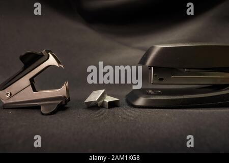 Stapler verses staple remover Office conflict example Stock Photo