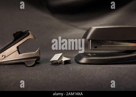 Stapler verses staple remover Office conflict example Stock Photo