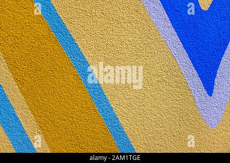 A fragment of the surface of a modern compound plastered wall with a rough embossed texture pattern painted with decorative abstract colors and lines Stock Photo