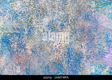 A fragment of the surface of a modern compound plastered wall with a rough embossed texture pattern painted with decorative abstract colors and spots Stock Photo
