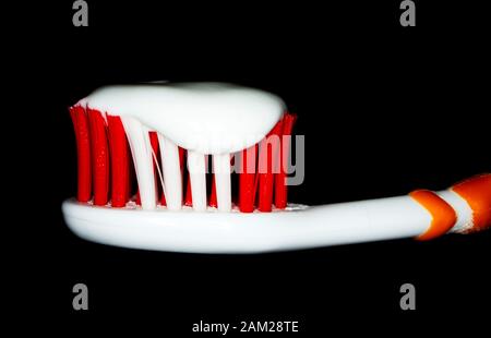 Toothbrush and white toothpaste on black background. Stock Photo