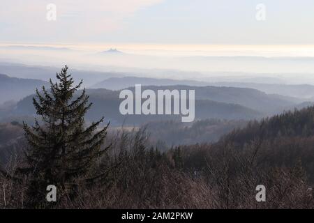 View of the Bohemian Paradise landscape on a clear day, with fog lying in the valleys. Trosky castle can be seen in the background. Czech Republic. Stock Photo