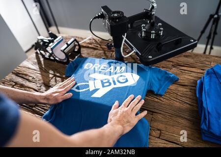 Man Printing On T Shirt In Workshop Stock Photo