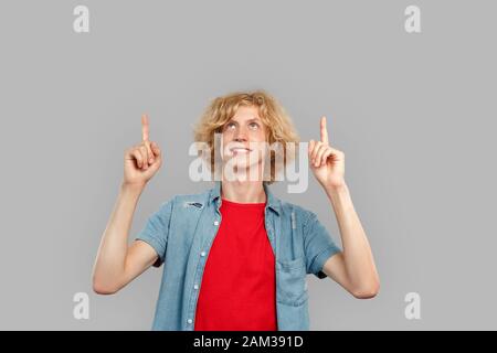 Young adult man pointing up with finger Stock Photo