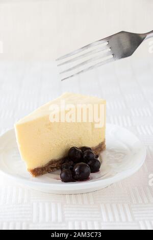 Slice of classic cheesecake on white texture background. Selective focus. Copy space Stock Photo