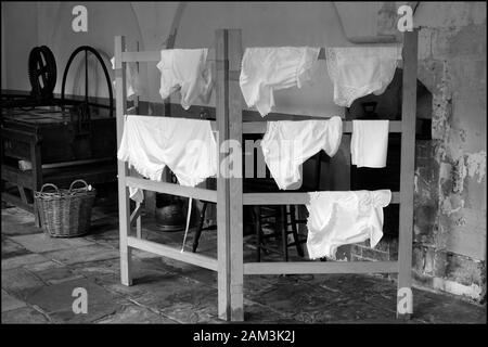 clean crisp white washing hanging on vintage wooden airing horse Stock Photo