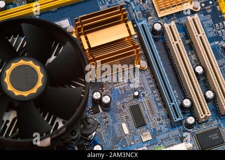 Computer motherboard with cooling system and fan. Computer details and diagrams. Equipment for the work of an engineer. Server microcircuit. Stock Photo