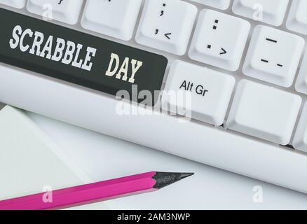 Conceptual hand writing showing Scrabble Day. Concept meaning a day to celebrate the popular board game created in 1938 White pc keyboard with note pa Stock Photo