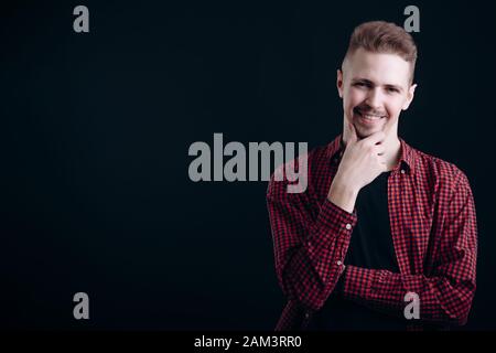 Young Handsome Guy Smiling and Rubbing Chin Stock Photo