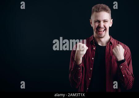 Young Man Shows Success Emotions, His Fists Clenched Stock Photo